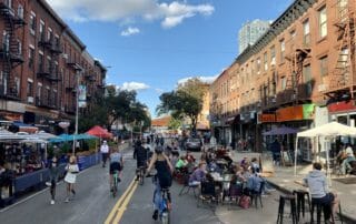 open street on 5th avenue with diners and cyclists