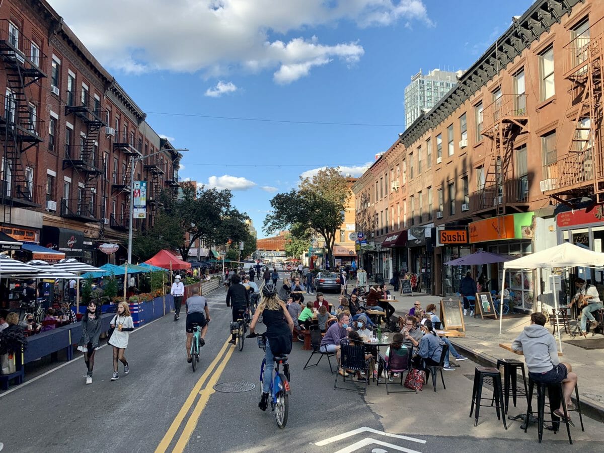 open street on 5th avenue with diners and cyclists